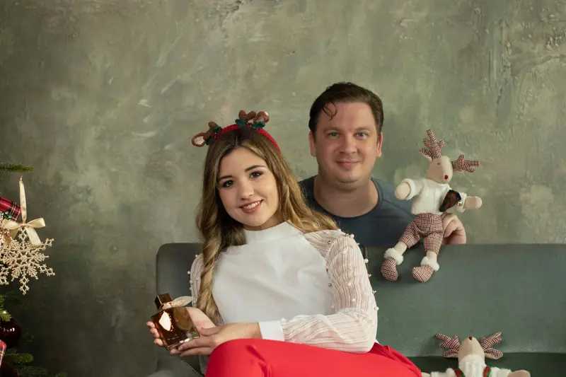 Dajka Gábor és egy modell parfümmel, karácsonyi stúdiódíszletben